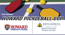 Graphic promoting the 2nd Annual Howard Pickleball Cup, featuring two pickleball paddles and balls on a court, with logos for Howard Community College and Johns Hopkins Howard County Medical Center.