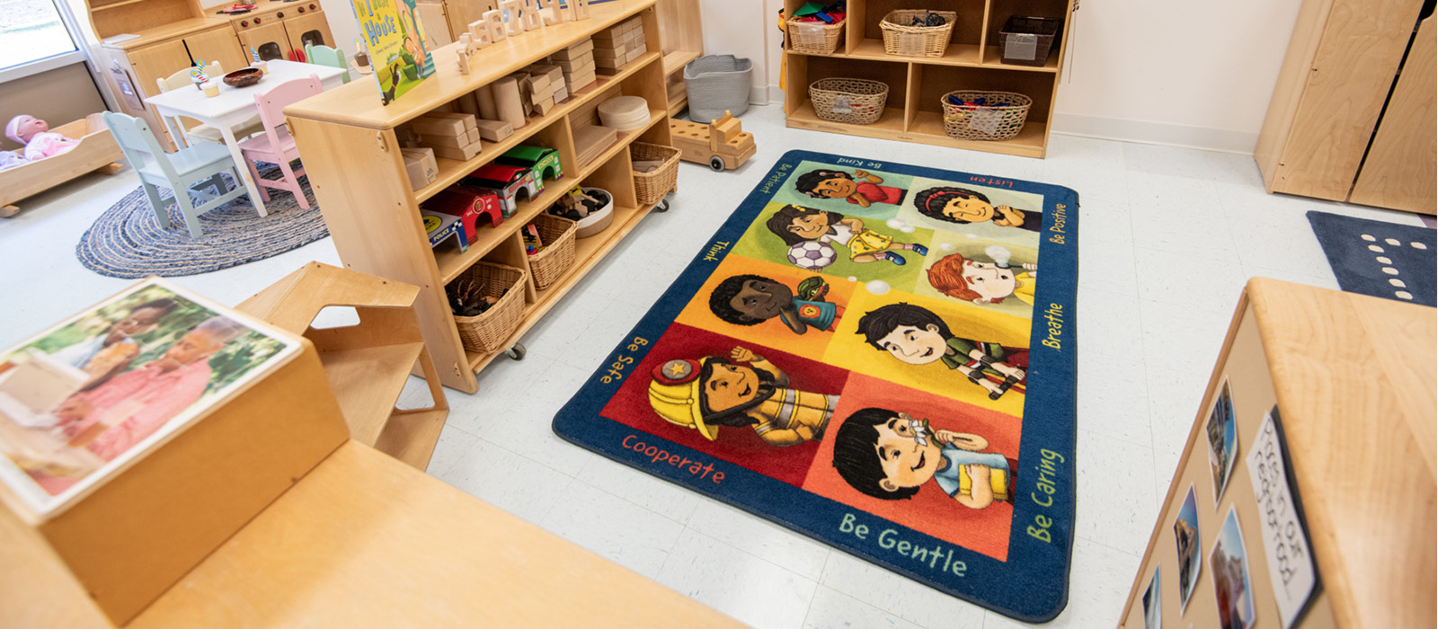 Children's Learning Center classroom photo with colorful rug and cubbies.